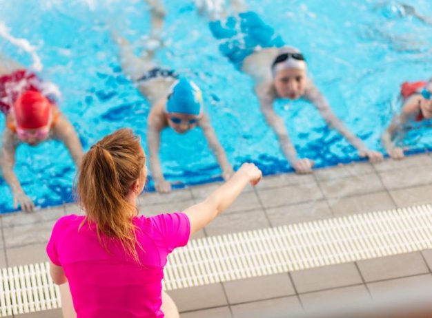 kids learning to swim with their instructor